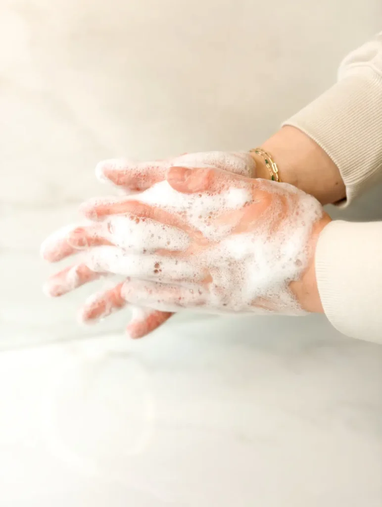 Washing hands with a bar of soap made by Basil Soaps